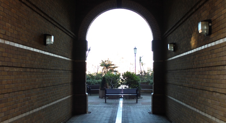 Seating area with benches and plants, viewed through an archway